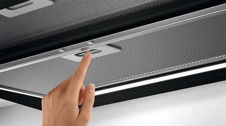 Hand inserts filter in cooked hood